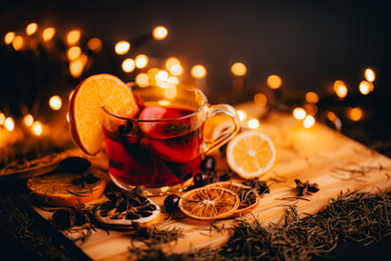Christmas mulled wine, Drink with dried fruits and berries, Winter hot tea in a glass and spices on a wooden background.	
