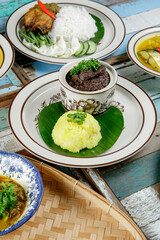a plate of yellow glutinous rice ( pulut kuning ) with rendang