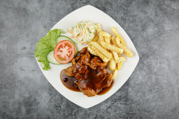 a plate of chicken chop set come with french fries and coleslaw