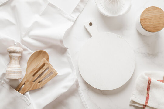 Culinary background, kitchen utensils and apron on kitchen countertop with blank space for any recipe or menu text