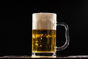 A cold fresh beer in front of a black background