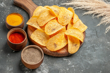 Close up view of delicious potato chips spices with ketchup on gray background
