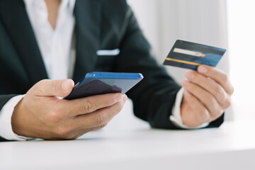 Online Payments Man's hands hold a smartphone and use credit cards to shop online, article websites, blogs, e-commerce sites.