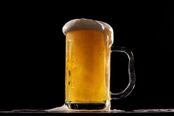 A cold fresh beer in front of a black background