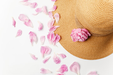 Summer, spring concept, straw braided hat, pink peony flowers and petals on white