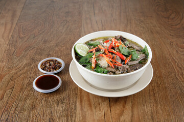 a bowl of beef soup with bbq sauce and chili paste