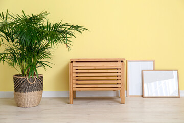 Wooden chest of drawers near color wall in room