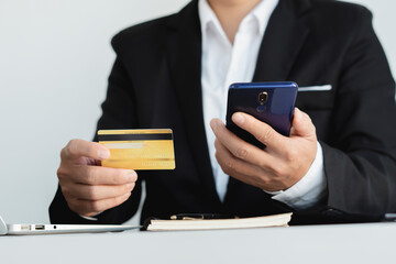 Online Payments Man's hands hold a smartphone and use credit cards to shop online, article websites, blogs, e-commerce sites.