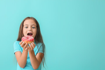 Cute little girl with sweet donut on color background