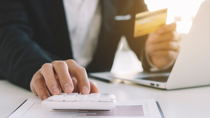 Businessmen are using a calculator to calculate their credit card balance to cover future spending.