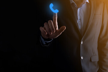 Businessman in suit on black background clicks on phone icon.Call Now Business Communication...