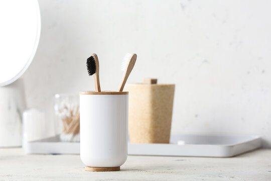 Holder With Wooden Toothbrushes On Table In Bathroom