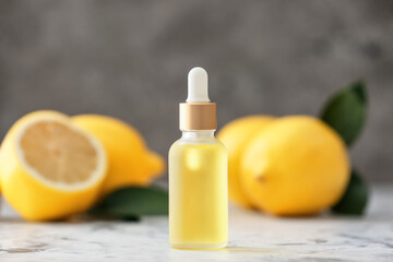 Bottle with lemon essential oil on table
