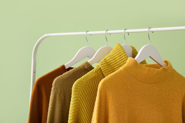 Rack with clothes on color background - obrazy, fototapety, plakaty