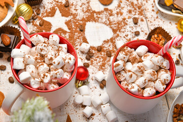 sweet food top view background for merry christmas or new year holiday decoration - chocolate candies, tangerines, cookies, marshmallow and cocoa latte on white wood