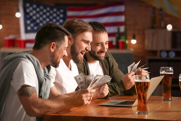 Happy men after winning of their sports bets in pub