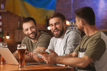 Happy men after winning of their sports bets in pub