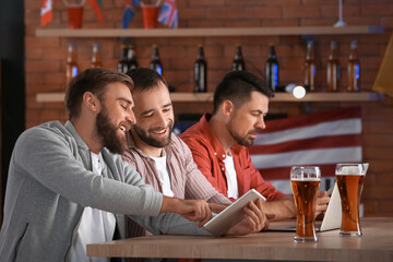 Happy men after winning of their sports bets in pub