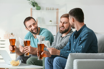 Happy men after winning of their sports bets at home