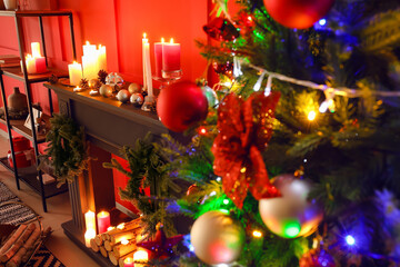 Burning candles on mantelpiece decorated for Christmas