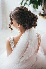 Wedding hairstyle. The bride in a dress. Wedding veil. Hairstyle with curls.