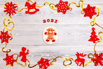 New Year 2021. Christmas greeting background. Holiday gifts and Christmas sales. The symbol of the year bull on a wooden background with elegant sparkling ornaments and snowflakes.