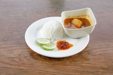 a plate of nasi berlauk with beef curry
