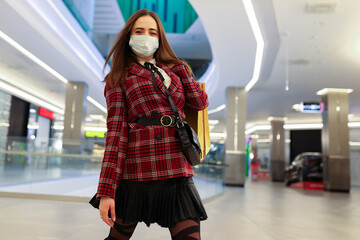 Fototapeta premium Young woman in protective mask with shopping bags