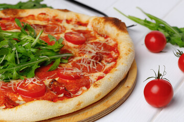 Pepperoni pizza on board on white wooden table