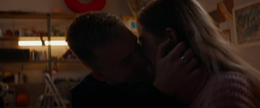 Teenagers sitting close to each other, having an intimate moment, first kiss. Hesitate, love, teen life. Shot with 2x anamorphic lens