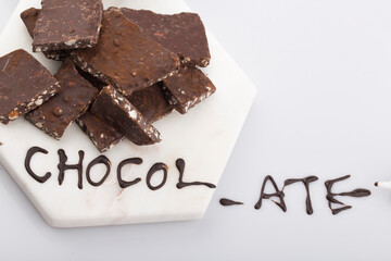 Broken or cracked chocolate chips pieces isolated on white background.