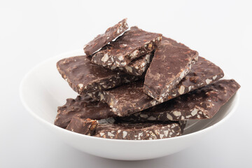 Broken chocolate chips pieces isolated on white background.