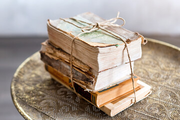 Old 100 years books on antique table closeup. History, knowledge, nostalgia, old age concept. Retro style.