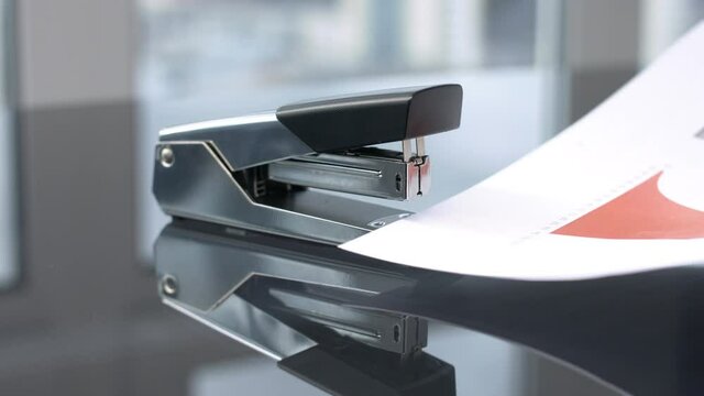 Female Hand Staple Paper Files By Binder Clip. Close Up.