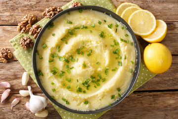 Delicious Greek Skordalia made from mashed potatoes with garlic, lemon, nuts and olive oil close-up in a plate on the table. horizontal top view from above