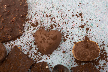Broken almone chocolate pieces with cocoa powder.