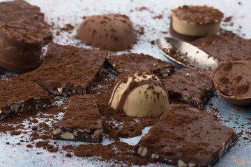 Broken almone chocolate pieces with cocoa powder.