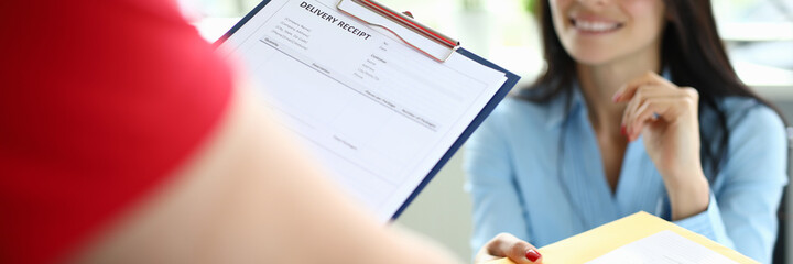 Courier delivers parcel mail to a businesswoman at her desk. Express mail delivery service by...