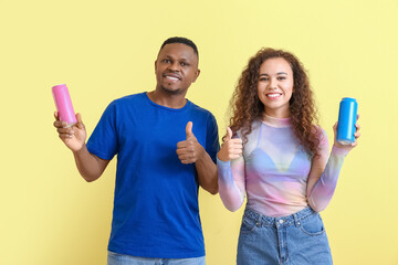 African-American couple with soda showing thumb-up on color background