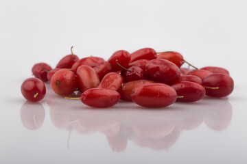 Pile of fresh cornus fruit on a white background.