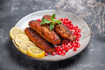 front view long meat cutlets with lemon and pomegranates on grey background photo meal roll