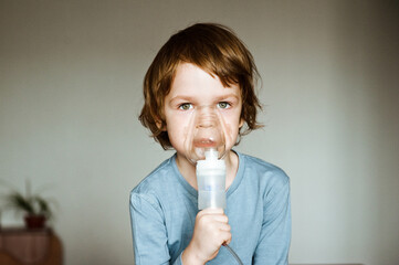Cute boy have a problem with chest coughing holding inhaler mask, Child using the volumtic for...