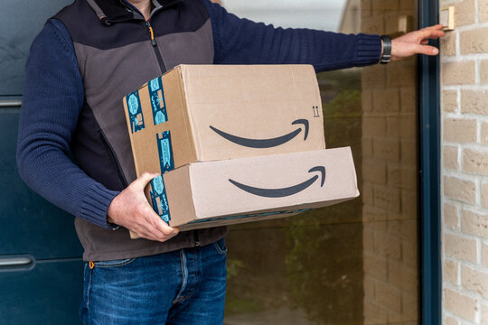 Lille, France - December 18, 2020 : Man delivers Amazon Prime package ordered on the amazon site