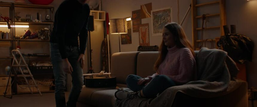 Teenager boy playing guitar to a girl he likes. New relationship start. Hesitate, love, teen life. Shot with 2x anamorphic lens