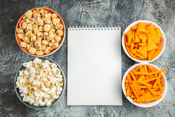 top view different snacks popcorn rusks and cips on the light background snack movie cinema