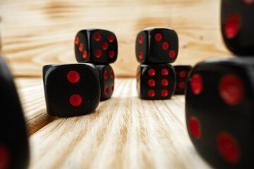 Macro of black tossed dice on wooden background