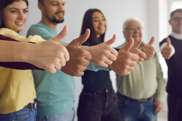 Diverse people of different age and race standing in row and showing thumbs up