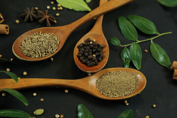 Wide variety spices and herbs on background of black table