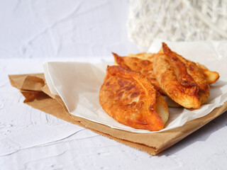 Appetizing homemade fried pies on kraft papers and white background