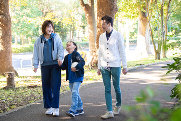 公園で仲良く散歩をする若い夫婦たち